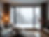A cozy living room interior with a large, modern window showing a snowy landscape outside,