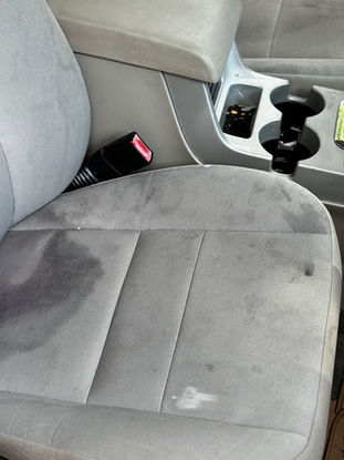 Interior of Ford SUV before detailing by Oak Cliff Detailing in Dallas, TX – noticeable liquid stains on cloth seats.