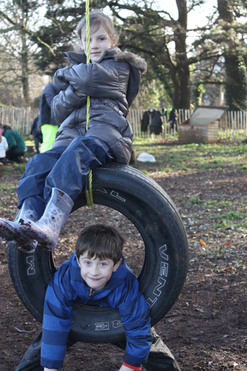 Forest School children on a rope tire