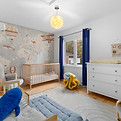 Chambre d’enfant ou d’adolescente décorée avec un mur floral, rideaux roses et mobilier blanc — ambiance douce idéale pour la valorisation d’un espace familial.