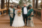 Multi-cultural couple standing on deck outdoors with brides Nigerian parents in cultural green cloth