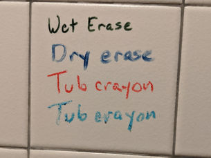 Test of wet erase, dry erase, and two colors of tub crayons on tile shower wall.