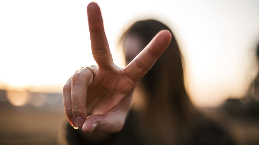 Woman does peace sign with her fingers.
