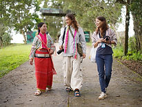 Travelers walking with local hill tribe community members in Northern Thailand.