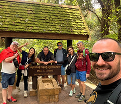 Group of travelers with local guide Chay at a traditional Northern Thai cultural site.