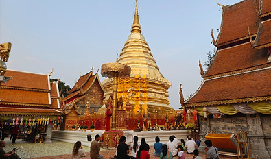 Travelers visiting Wat Phra That Doi Suthep and the Hmong Village in Chiang Mai at sunset.