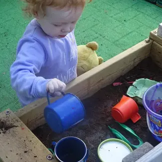 child playing with a mud kitchen