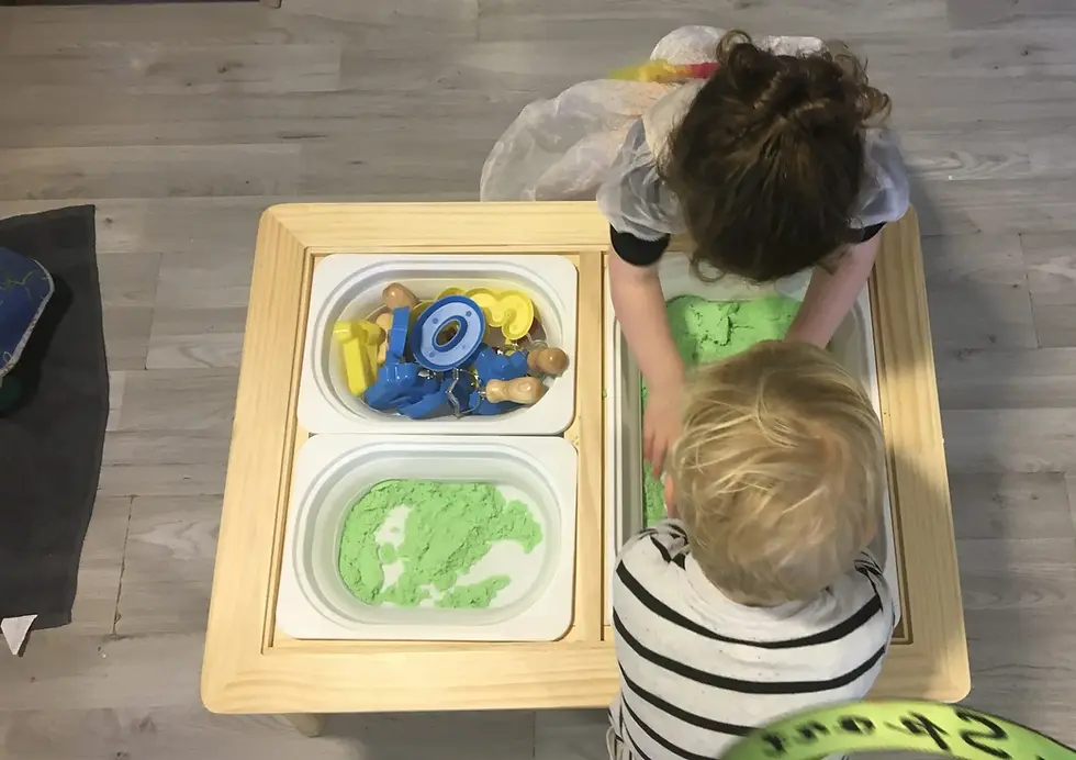 children playing with green sand in nursery room 