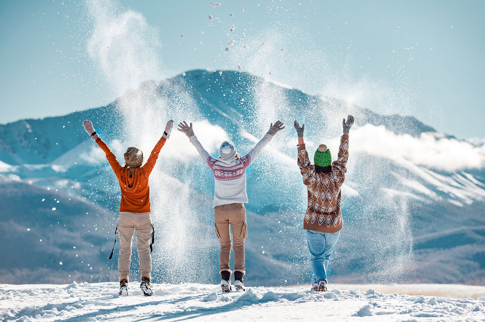 Three happy adult girls are having fun and throws first snow on background of mountains_ed
