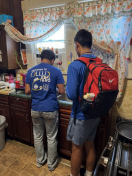 two people standing in a kitchen