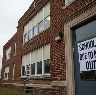 This exterior photograph shows a red brick school building with a sign on the door announcing its closure due to a measles outbreak, while a yellow bus waits in the background.