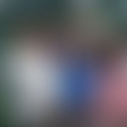 A promotional photo of the main cast of the TV show ER, featuring nine actors in scrubs and lab coats in a hospital setting.