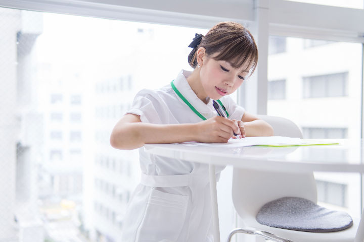 nurse writing down on a chart