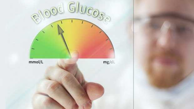 Esta imagen muestra un primer plano de un hombre que usa guantes de laboratorio y toca una pantalla virtual de glucosa en sangre. Un medidor indica un nivel óptimo o saludable.