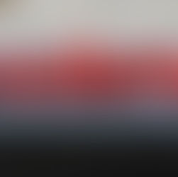 Una toma de cerca del logo de Moderna montado en el exterior de un edificio. Las letras rojas tridimensionales están iluminadas, sobre una base gris con una fila de formas rectangulares azules también iluminadas.