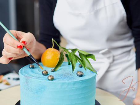 A woman in an apron carefully decorates a bright blue cake with with fruit - capturing the creativity and care often at the heart of a side hustle.