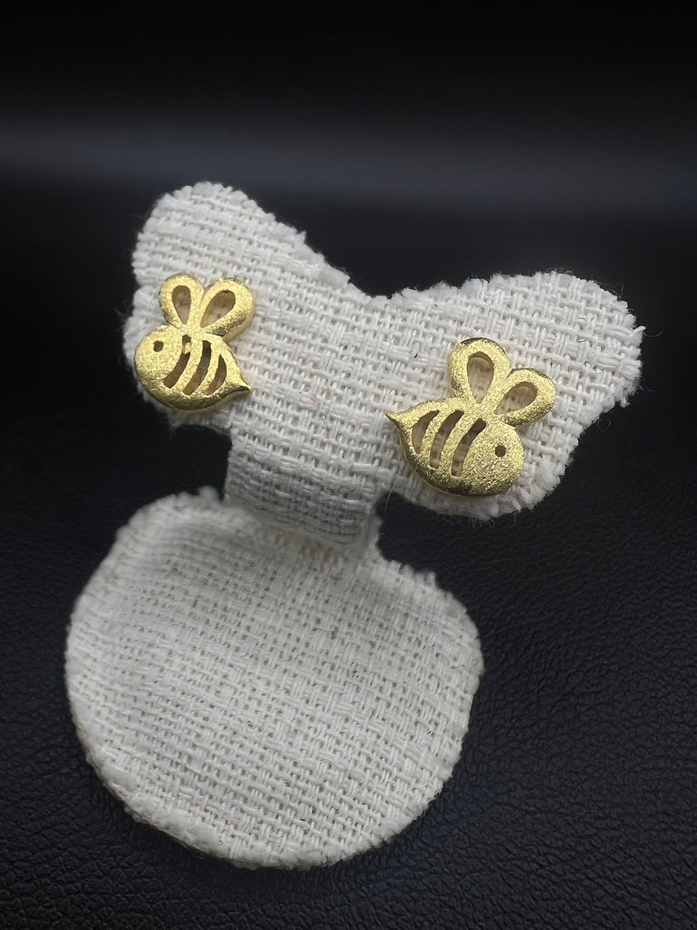 Gold-tone bee stud earrings on padded fabric stand