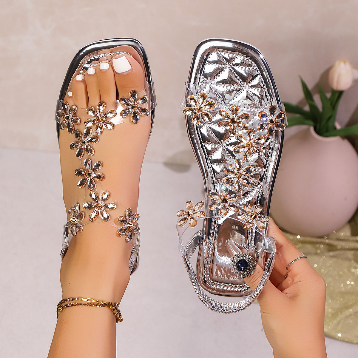 A pair of women's square-toe flat sandals, stylish silver sandals adorned with f