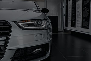 Close-up of a white Audi's front headlight, grille, and polished exterior, representing DMC Mobile Auto Detailing's specialty detailing services, including headlight restoration and paint care in Joliet, IL.