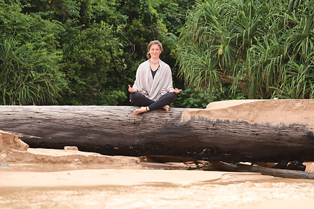 girl sitting on the stone on the beach, smiling in positive and beautiful atmosphere