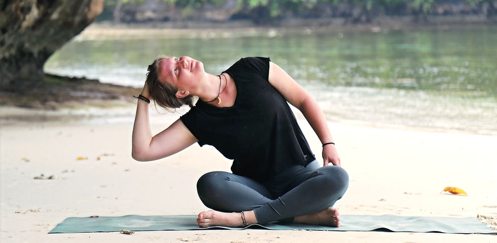 Žena cvičící jednoduchou pozici jógy pro začátečníky na písečné plaži s hřejivým tropickým sluncem.