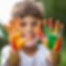 young boy smiling showing paint on his hands.jpg