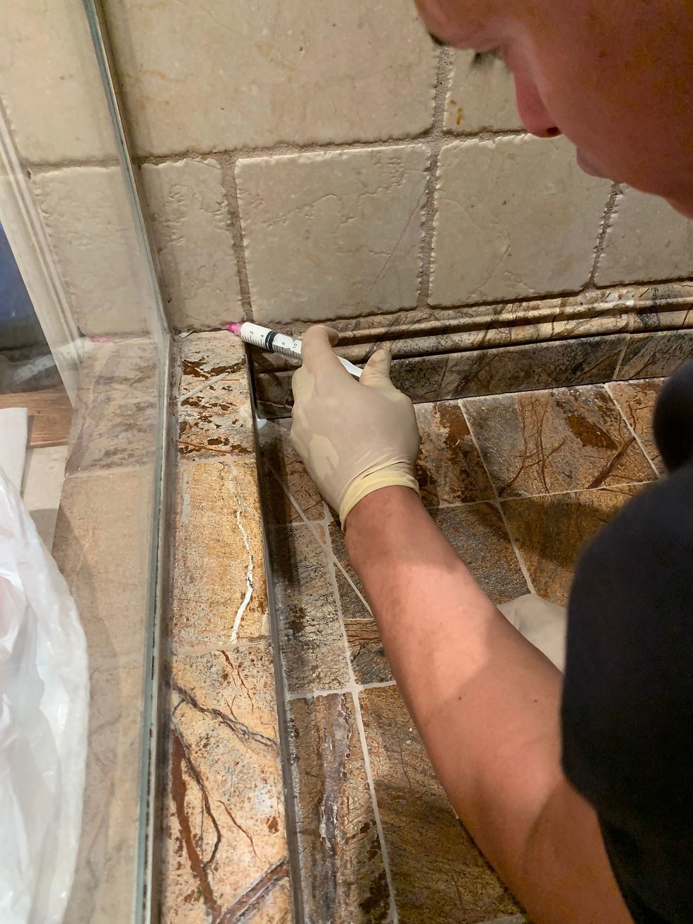 Close-up view of natural stone shower wall with water droplets