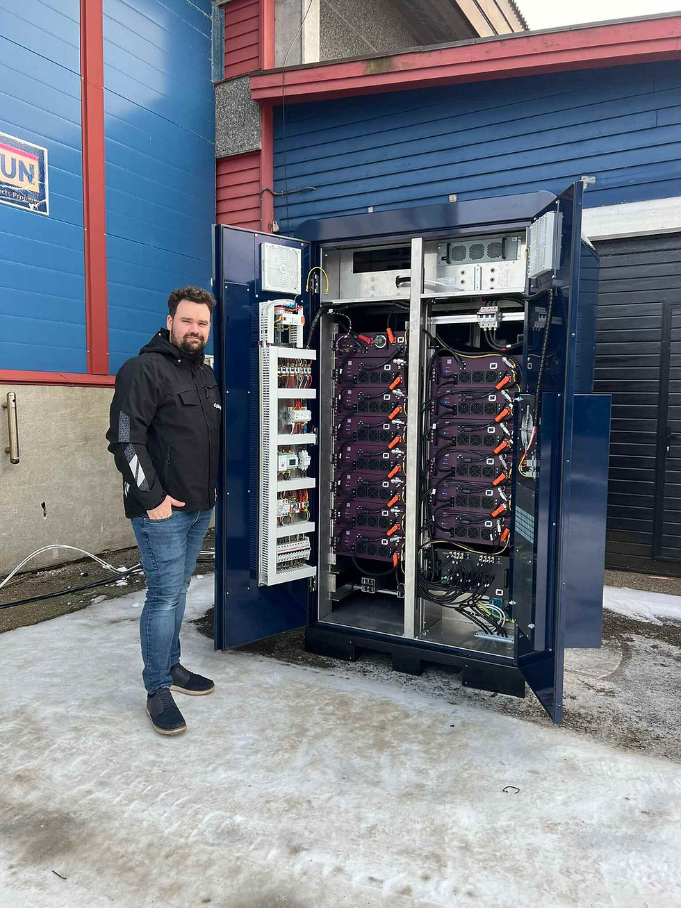 EKODA employee in front of a mobile battery system.