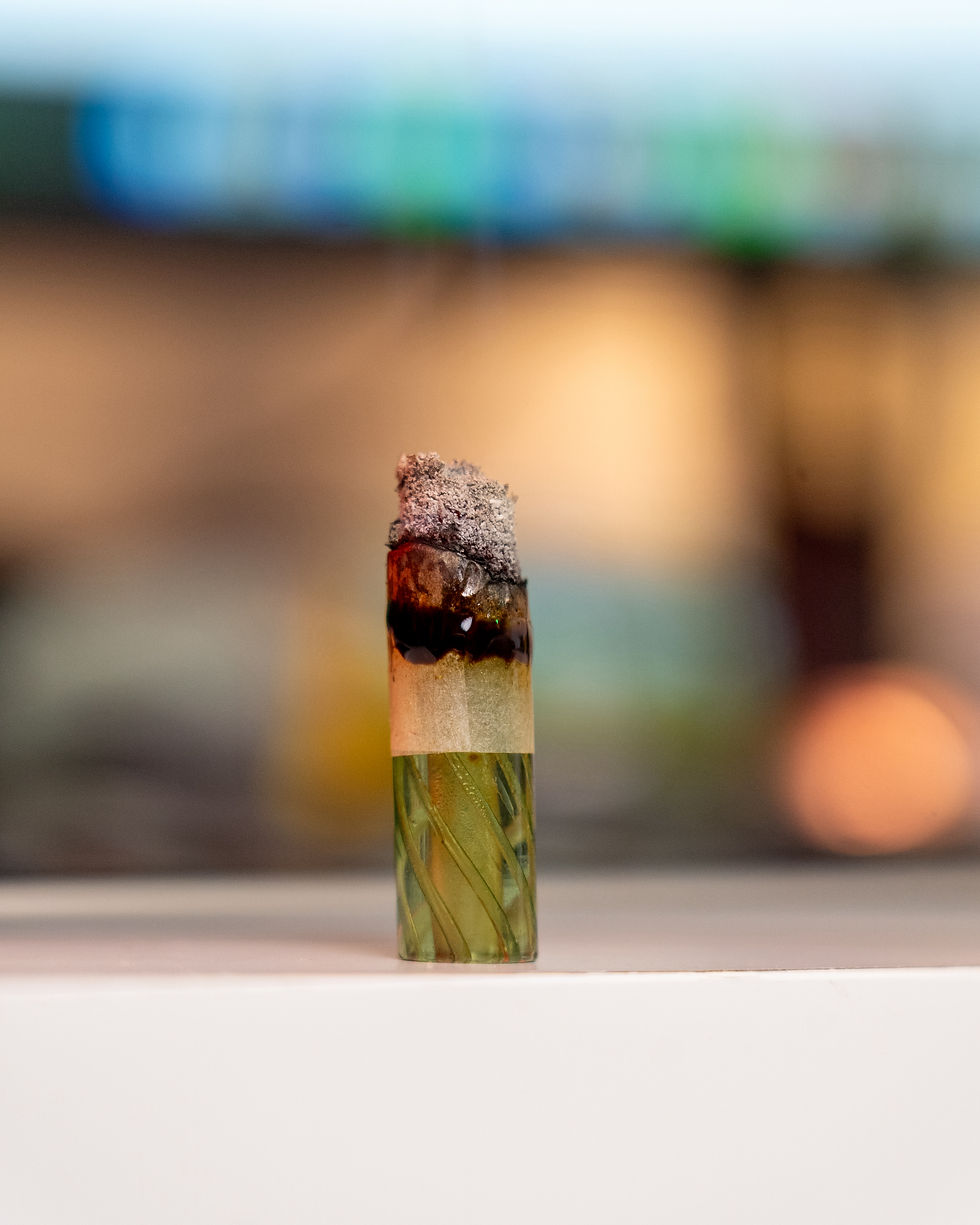 Electric Kool-Aid #6 joint showing pearl-gray ash and a thick, dark oil ring above a green glass RipTip.
