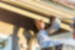 Professional installing 6-inch seamless aluminum gutters on a residential roofline.