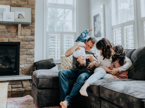 Family with 2 kids are playing on the sofa