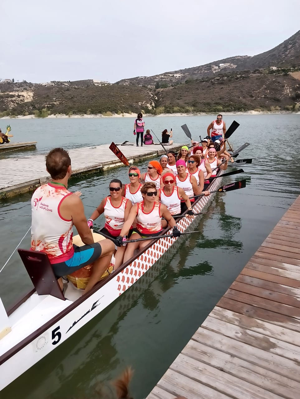 Close-up of a dragon boat paddle cutting through the water during a team practice