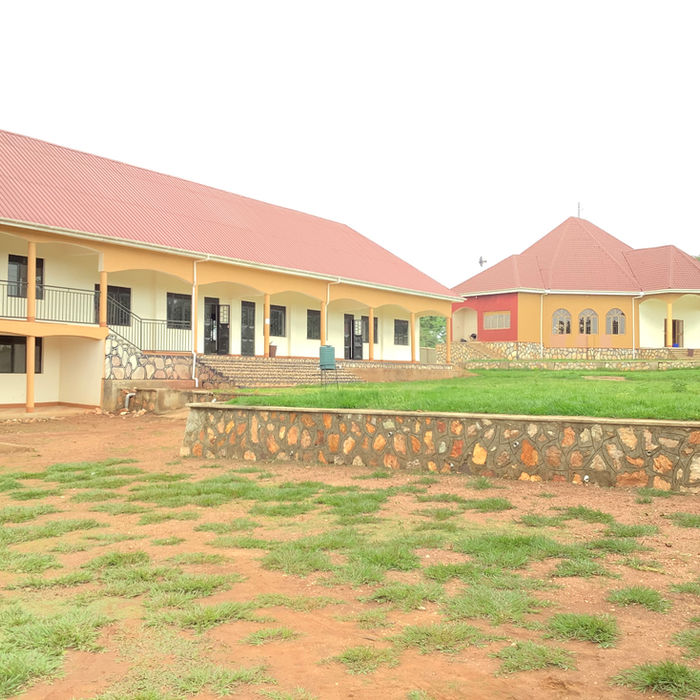 Exterior shot of Uganda Schools, buildings with red roofs and green lawns.