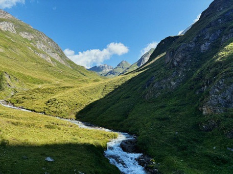 Mountain with juicy green grass while hiking a day trip with backpack