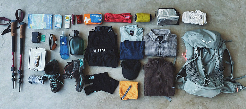 Flachlage-Foto einer kompletten Wanderausrüstung für eine Tagestour – Rucksack, Kleidung, Verpflegung und Sicherheitsausrüstung nach perfekter Packliste für sicheres und achtsames Tageswandern in den Bergen