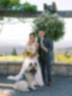a couple and their dog posing for a photo at their wedding
