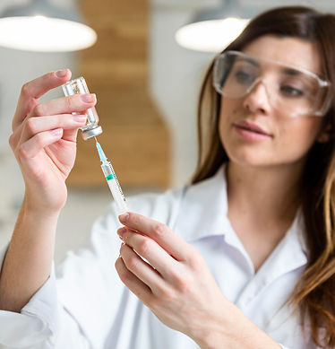 female-scientist-with-safety-glasses-holding-syringe-with-vaccine-lab.jpg