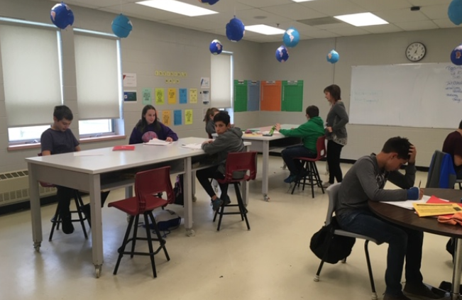 The tables are tall enough that students can stand comfortably to work or sit on a stool.