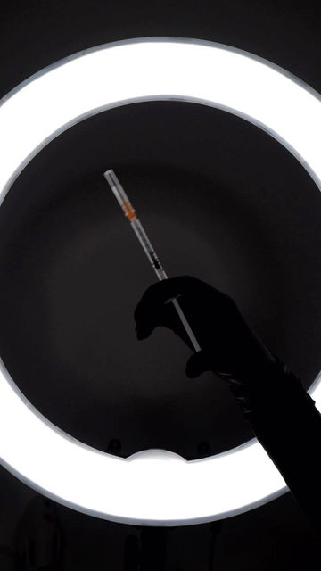 Skin booster syringe held under LED lighting before treatment at MC Laser & Beauty.