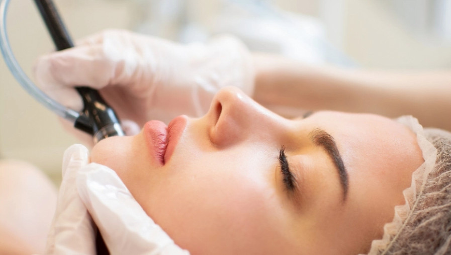 Woman receiving HYDRAFACIALS, facial treatment procedure at Divine Brazilian Wax & Spa Snellville Ga