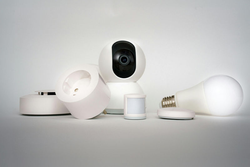 Collection of smart home devices including camera, lightbulb, and sensors on white background