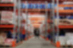 Industrial warehouse aisle with stacked inventory shelves for Amazon FBA fulfillment
