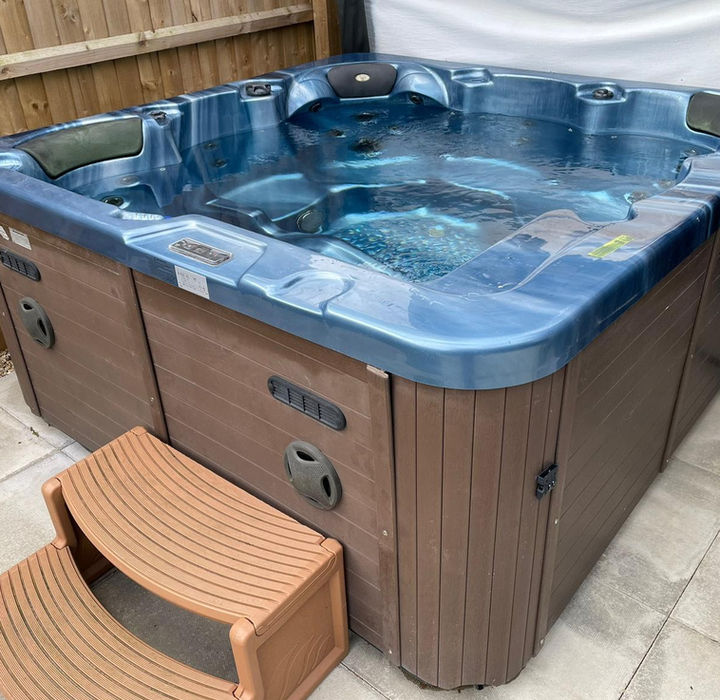 Exclusive-use hot tub at Maple Lodge illuminated by festoon lights under the Lincolnshire sky.