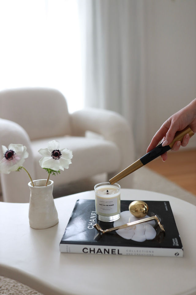 A hand poured scented candle in a glass jar and a Flint fire lighter in gold