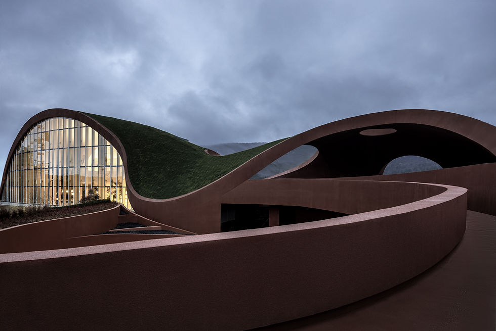 A red curving building with grass covering the top.