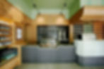 The counter of Smith Tea Cafe. The walls are green and the counter is surrounding by wooden casing.