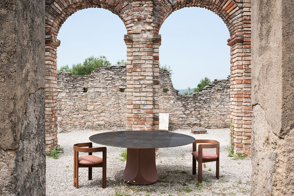 A round table from Tacchini pictured with Pigreco chairs in the ruins of an ancient building