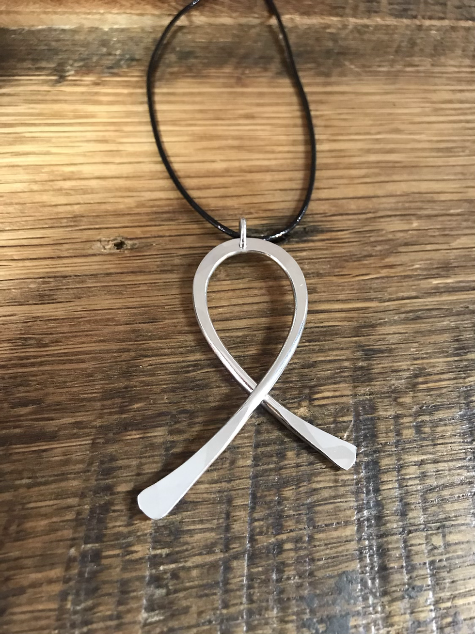 Thumbnail: Aluminum ribbon necklace on a wooden surface.