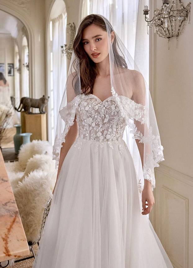 Abito da sposa linea A in tulle con scollo a cuore off shoulder, corpetto trasparente con pizzo ricamato e applicazioni floreali 3D, gonna ampia con strascico sweep