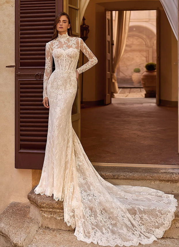 Abito da sposa sirena in pizzo con giacchino, scollo a cuore e lungo strascico.